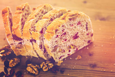 Freshly baked sliced sourdough cranberry nut bread on the table.の写真素材