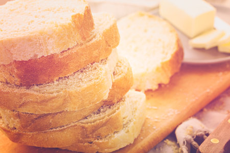 Freshly baked sourdough bread sliced on cutting board.の写真素材