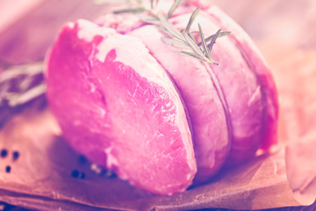 Organic pork lion roast with rosemary on wood farm table.の写真素材