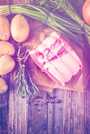 Organic pork lion roast with rosemary on wood farm table.の写真素材