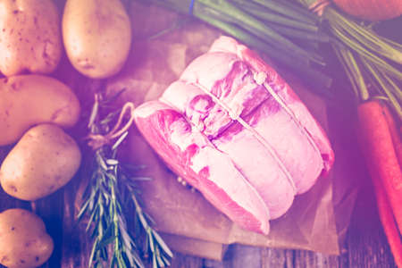Organic pork lion roast with rosemary on wood farm table.の写真素材