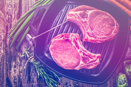 Organic pork lion chops of thick cut on cast iron frying pan.の写真素材