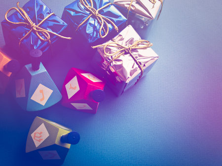 Colorful dreidels with presents on blue background.