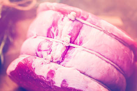Organic pork lion roast with rosemary on wood farm table.の写真素材