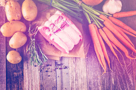 Organic pork lion roast with rosemary on wood farm table.の写真素材