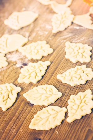 Cutting out Autumn leafs with cookie stamper to decorate pumpkin pie.