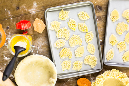 Cutting out Autumn leafs with cookie stamper to decorate pumpkin pie.