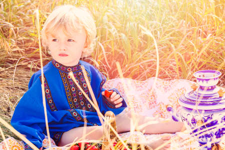 Russian children in traditional Russian costumes playing in the forest.の写真素材