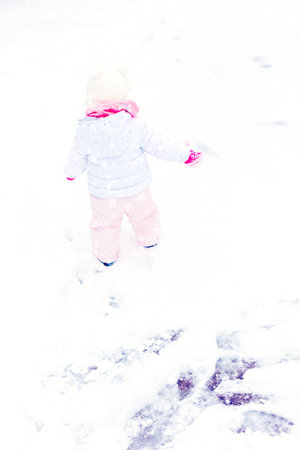 Cute toddler enjoying play in fresh snow.の写真素材