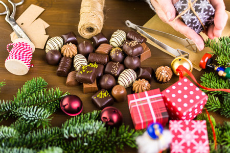Wrapping assorted chocolates in small boxes for Christmas presents.