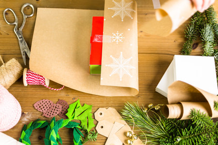 Wrapping Christmas gifts in recycled brown paper with vintage style at home.の写真素材