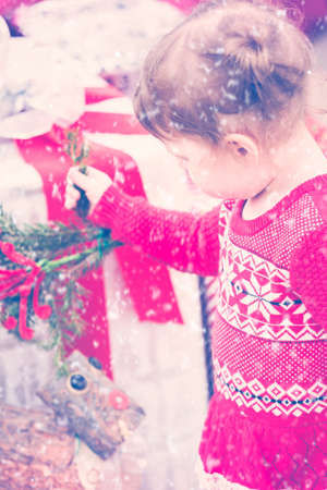 Cute toddler girl looking at Christmas presents.の写真素材