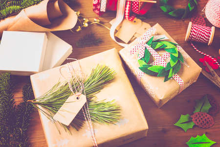 Wrapping Christmas gifts in recycled brown paper with vintage style at home.の写真素材