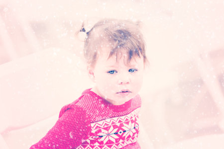 Cute toddler girl playing on white chairs.の写真素材