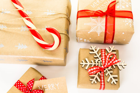 Christmas gifts wrapped in brown paper with red ribbons.