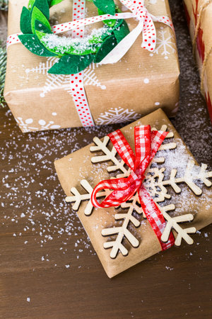 Christmas gifts wrapped in brown paper with red ribbons.