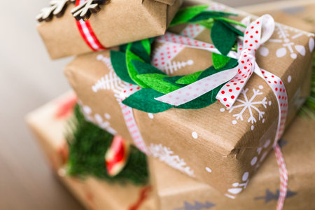 Christmas gifts wrapped in brown paper with red ribbons.