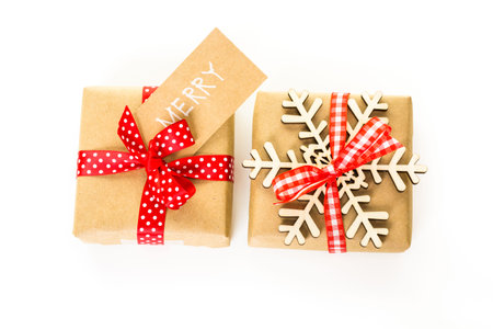 Christmas gifts wrapped in brown paper with red ribbons.