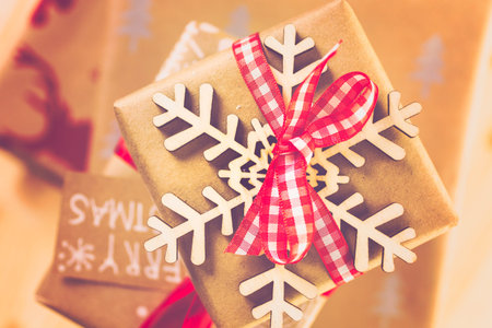 Christmas gifts wrapped in brown paper with red ribbons.