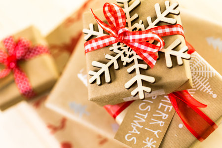 Christmas gifts wrapped in brown paper with red ribbons.