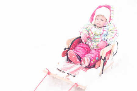 Toddler girl playing in fresh snow.