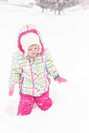 Toddler girl playing in fresh snow.の写真素材