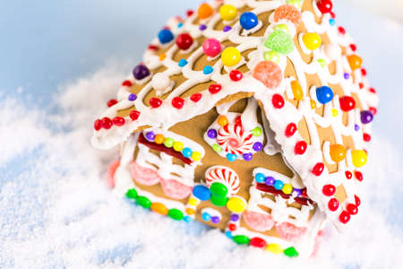 Gingerbread house decorated with white royal icing and bright candies.の写真素材