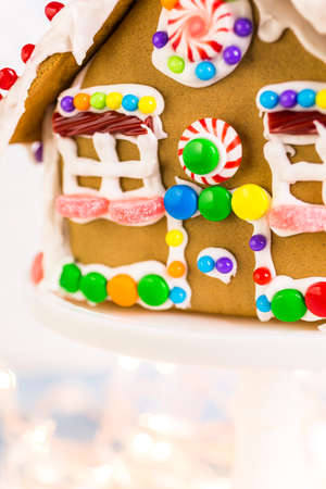 Gingerbread house decorated with white royal icing and bright candies.の写真素材