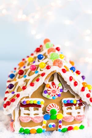 Gingerbread house decorated with white royal icing and bright candies.の写真素材
