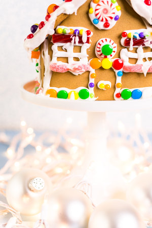 Gingerbread house decorated with white royal icing and bright candies.の写真素材