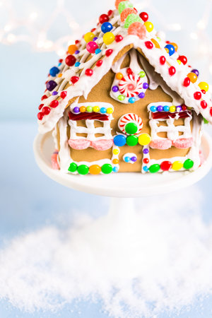 Gingerbread house decorated with white royal icing and bright candies.の写真素材