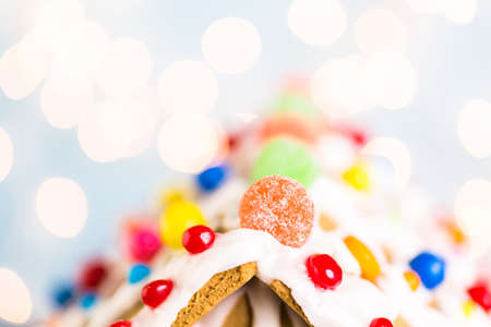 Gingerbread house decorated with white royal icing and bright candies.の写真素材
