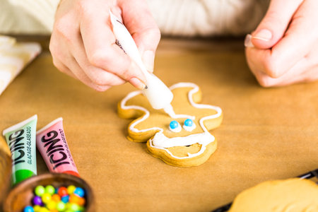 Decorating gingerbread cookies with royal icing and colorful candies.