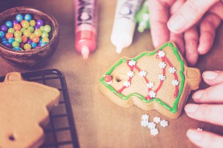 Decorating gingerbread cookies with royal icing and colorful candies.