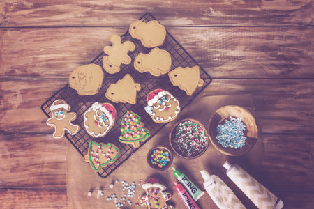 Decorating gingerbread cookies with royal icing and colorful candies.