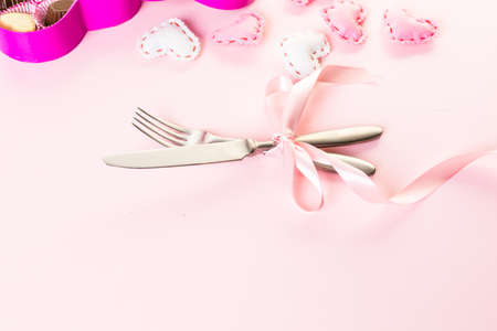 Utencils with pink ribbon on pink background.の写真素材