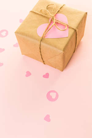 Gift box wrapped in recycled paper and decorated with pink heart.の写真素材