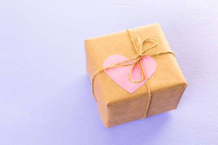 Gift box wrapped in recycled paper and decorated with pink heart.の写真素材