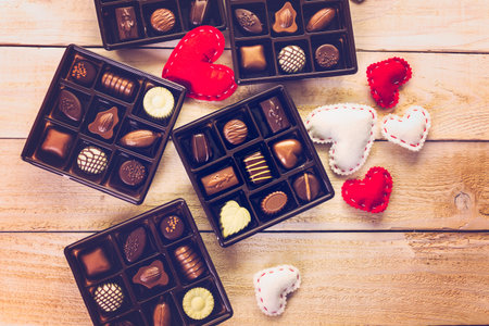 Assorted chocolates on wood table.