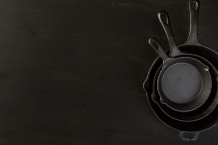 Traditional cast iron skillet on black wood table.