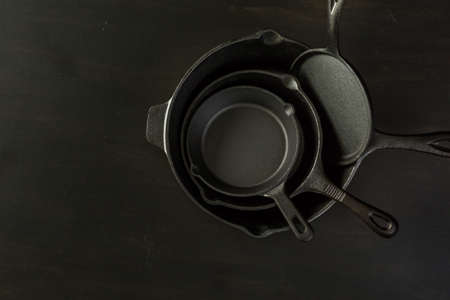 Traditional cast iron skillet on black wood table.の写真素材