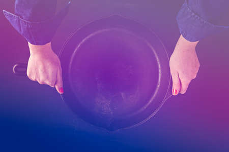 Traditional cast iron skillet on black wood table.の写真素材