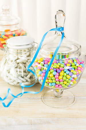 Multicolored candies in glass candy jars.