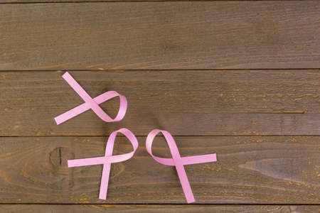 Womens health symbol in pink ribbon on wooden board.の写真素材