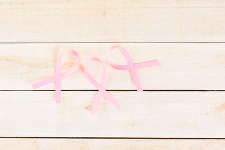 Womens health symbol in pink ribbon on wooden board.の写真素材