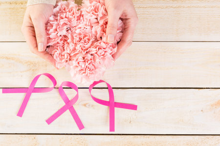 Womens health symbol in pink ribbon on wooden board.