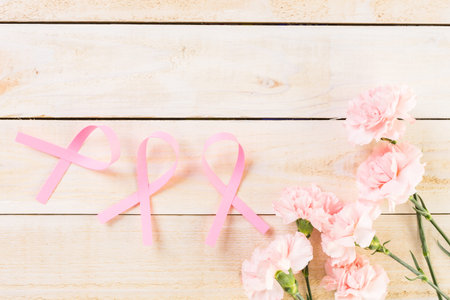 Womens health symbol in pink ribbon on wooden board.