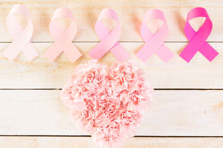 Womens health symbol in pink ribbon on wooden board.の写真素材