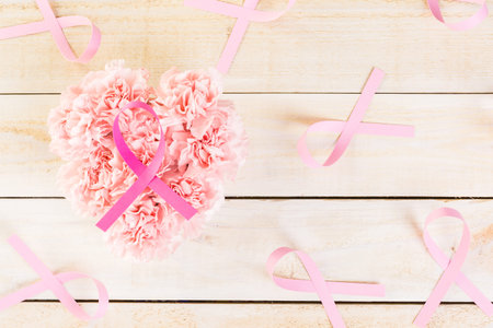 Womens health symbol in pink ribbon on wooden board.