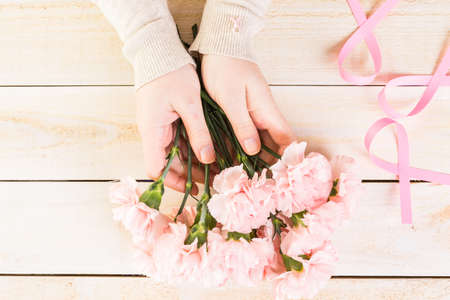 Womens health symbol in pink ribbon on wooden board.の写真素材